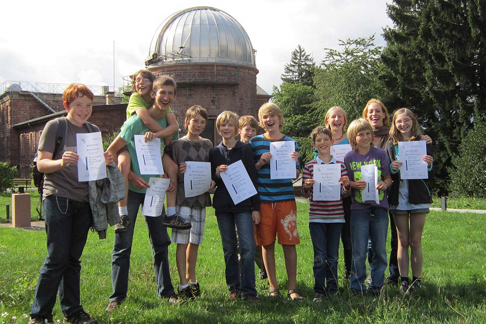 Teilnehmende zeigen ihre Teilnahme-Urkunden.